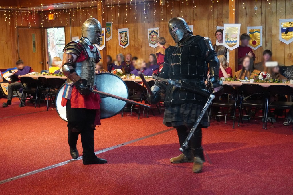 Ben Ward and John Latson have a friendly chat before proceeding with their heavy fighting demonstration at Siskiyou School in Ashland during the kids' Medieval Games event. April 16, 2026. Kids' faces are blurred for identity protection.