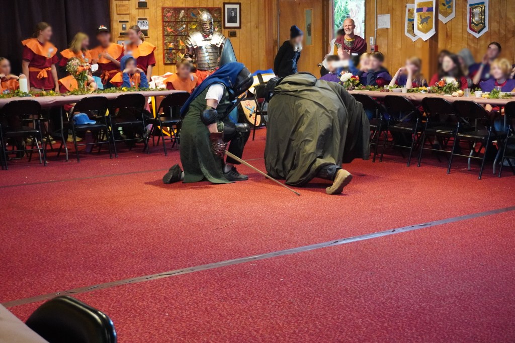 Chivalry shown by Cody Williams towards Conner Hammel after defeating him in a cut-and-thrust demonstration at Siskiyou School in Ashland, Oregon. April 16, 2026. Kids' faces are blurred for identity protection.