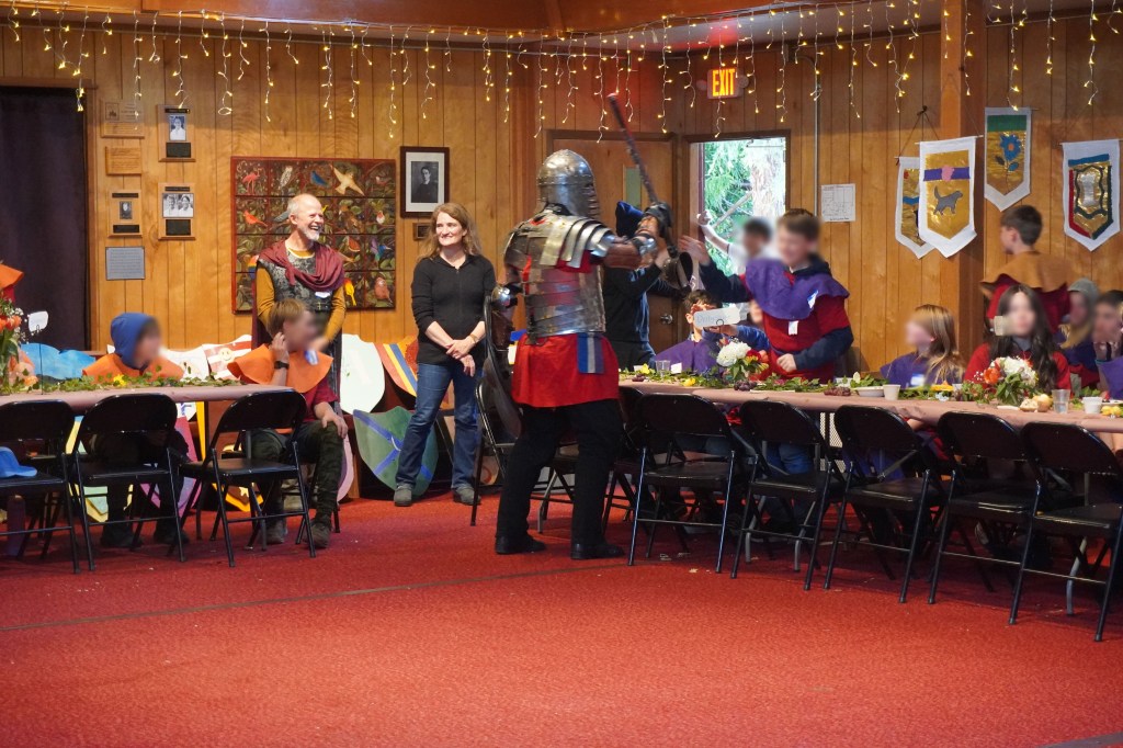Ben Ward lets the kids hit him on the helmet with his weapon at Siskiyou School in Ashland, Oregon. April 16, 2026. Kids' faces are blurred for identity protection.